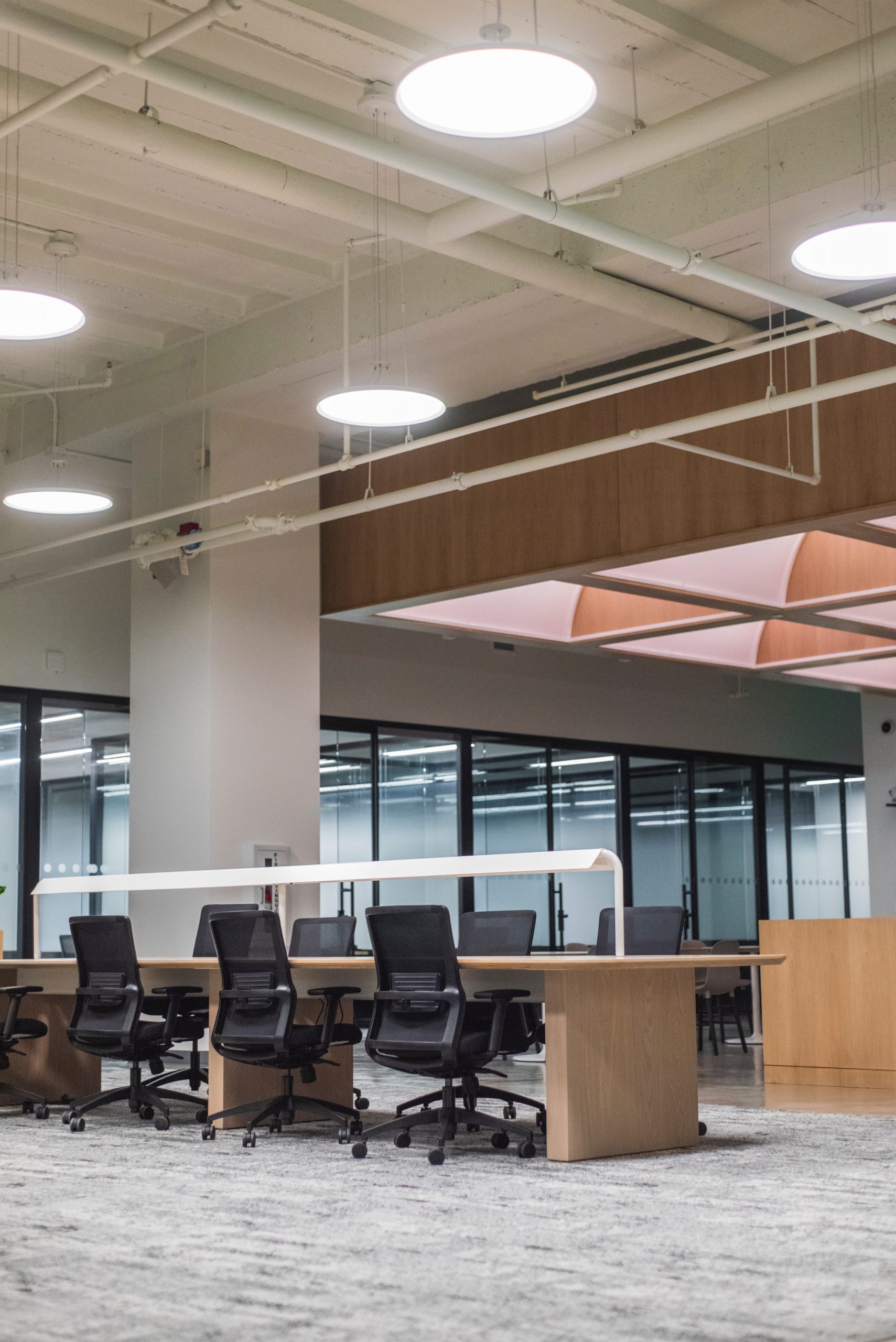 An office space with a long table with chairs next to it. 